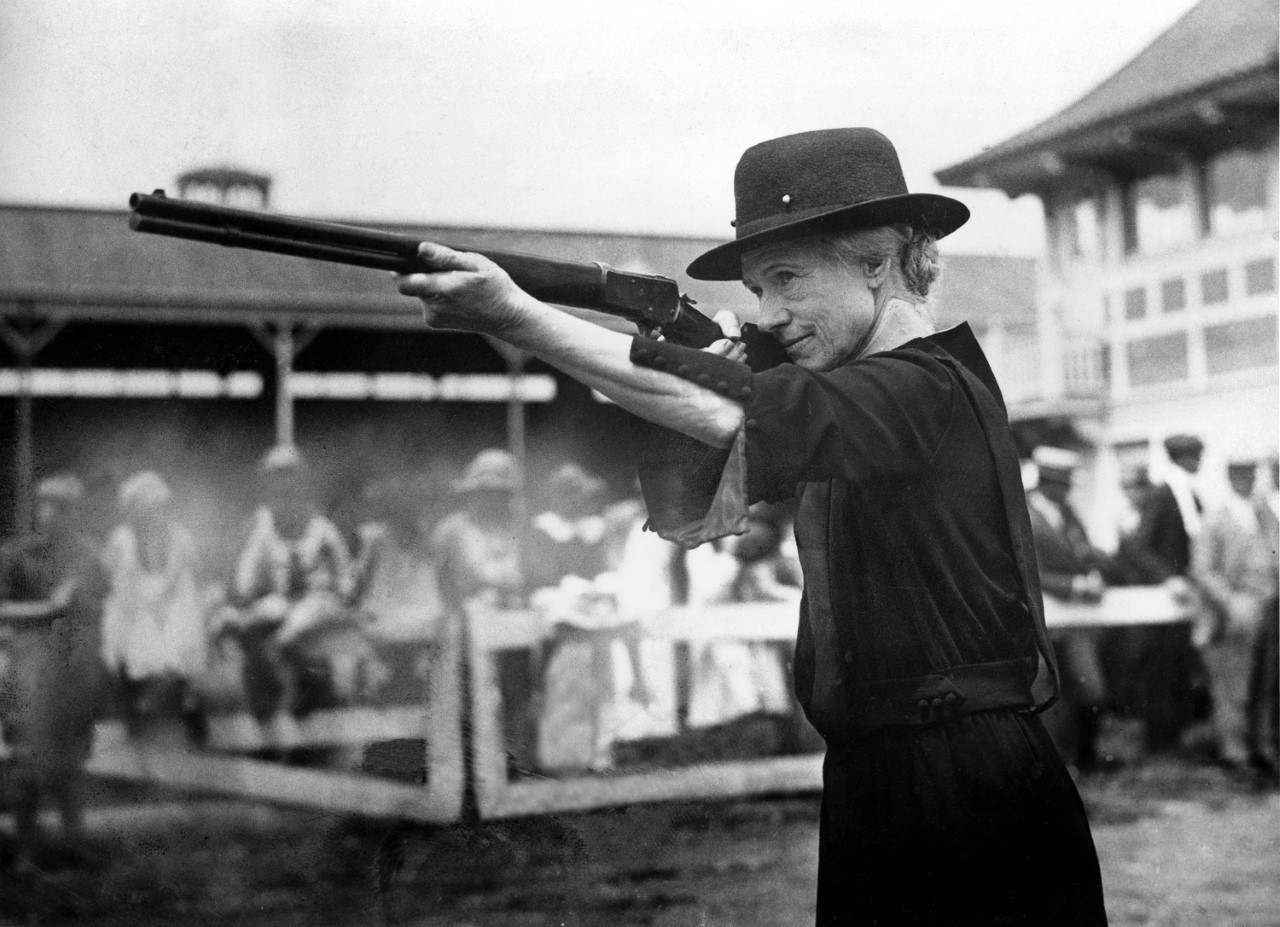 Annie Oakley takes aim with a Lever Action Rifle towards the end of her career