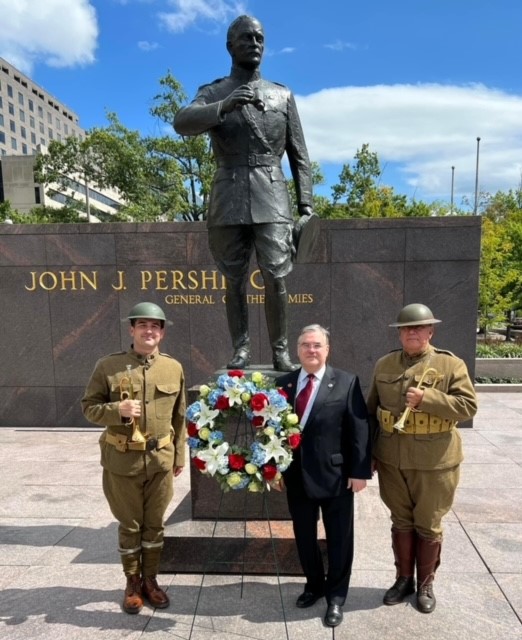 Pershing statue with three men standing in front of it