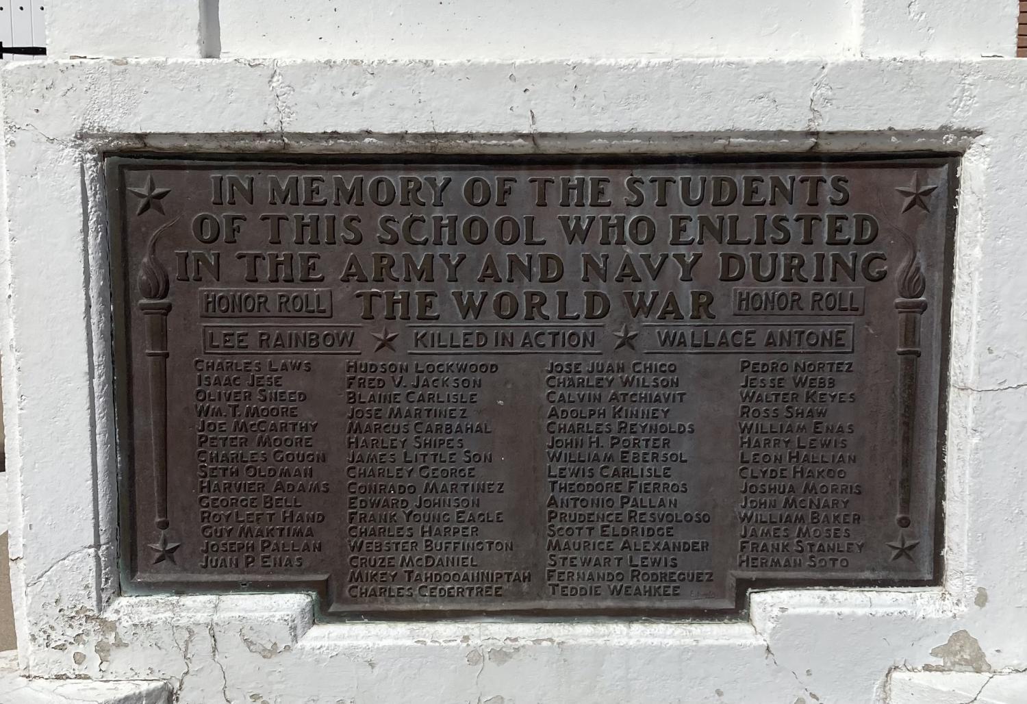 A concrete World War I memorial on the entry sidewalk at Memorial Hall includes a plaque with the names of 62 Phoenix Indian School students who enlisted in the Army and Navy. (Christina Estes/KJZZ)