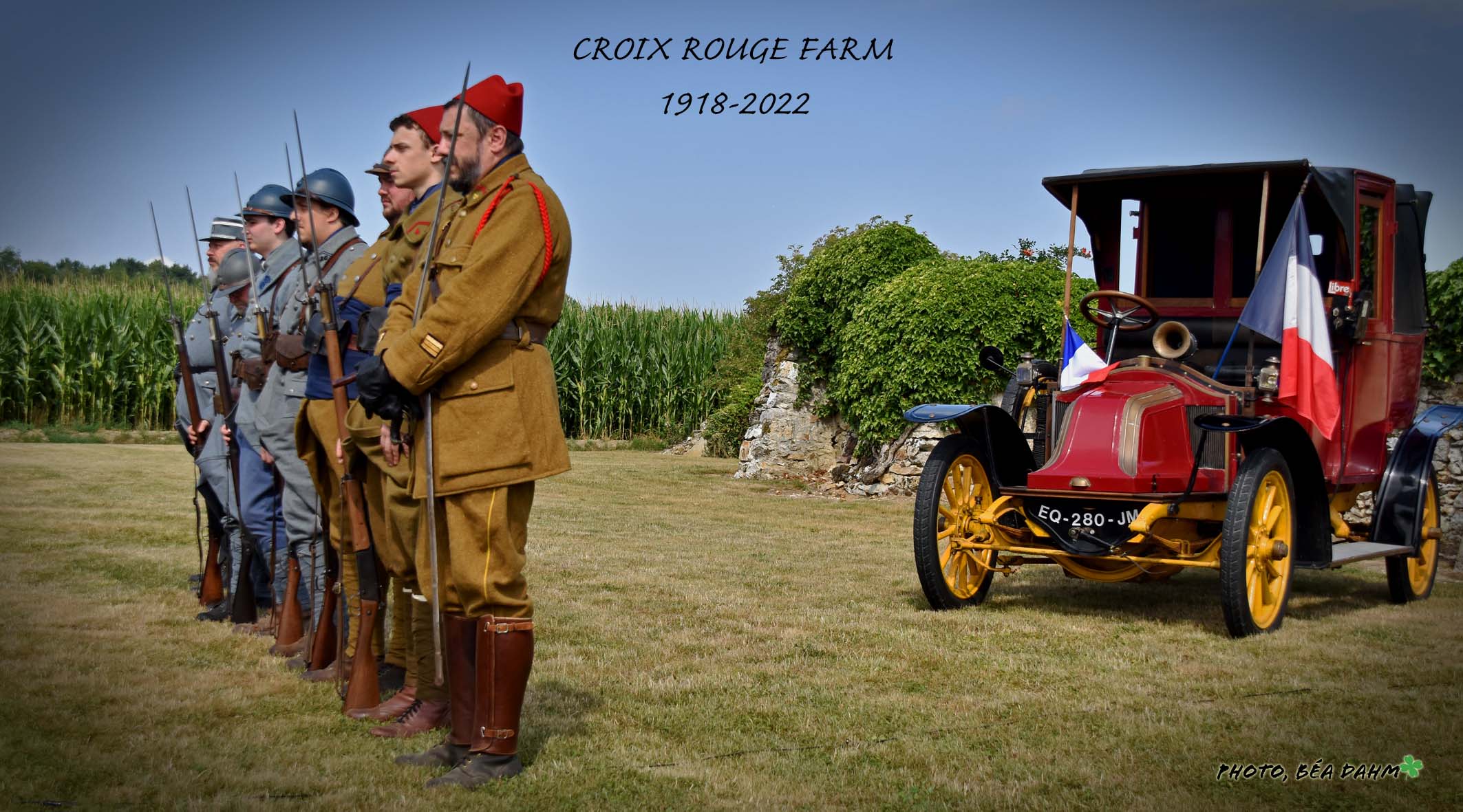 Reenactors stand in front of a 1910s automobile