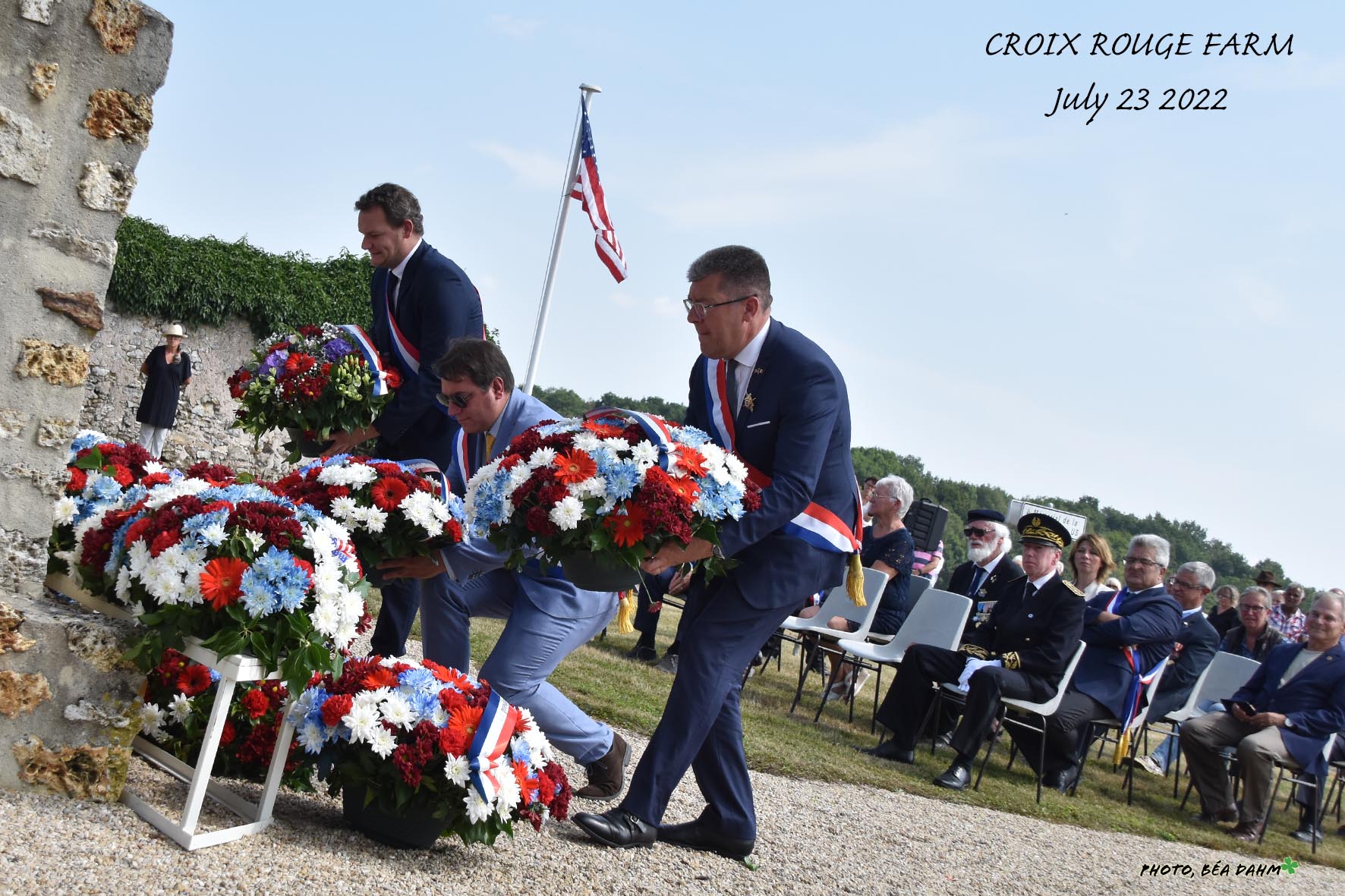 wreaths are placed with others at a brick and concrete wall