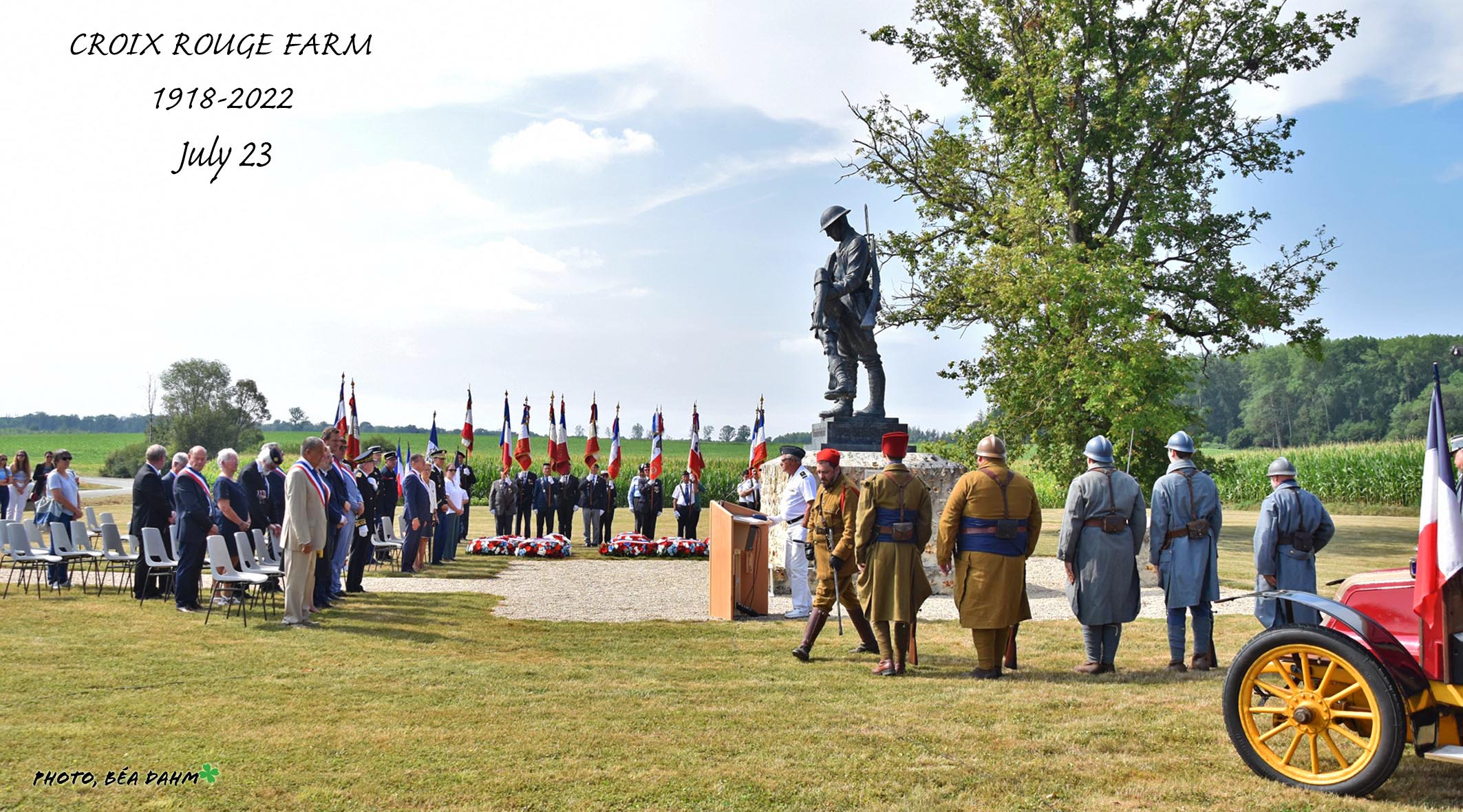 Soldiers, delegates, and reenactors shown in front of a WWI memorial