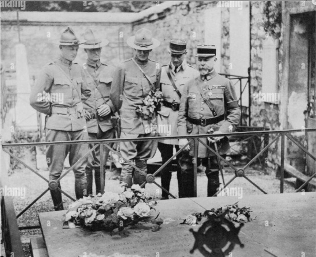 Five American officers in front of wreaths