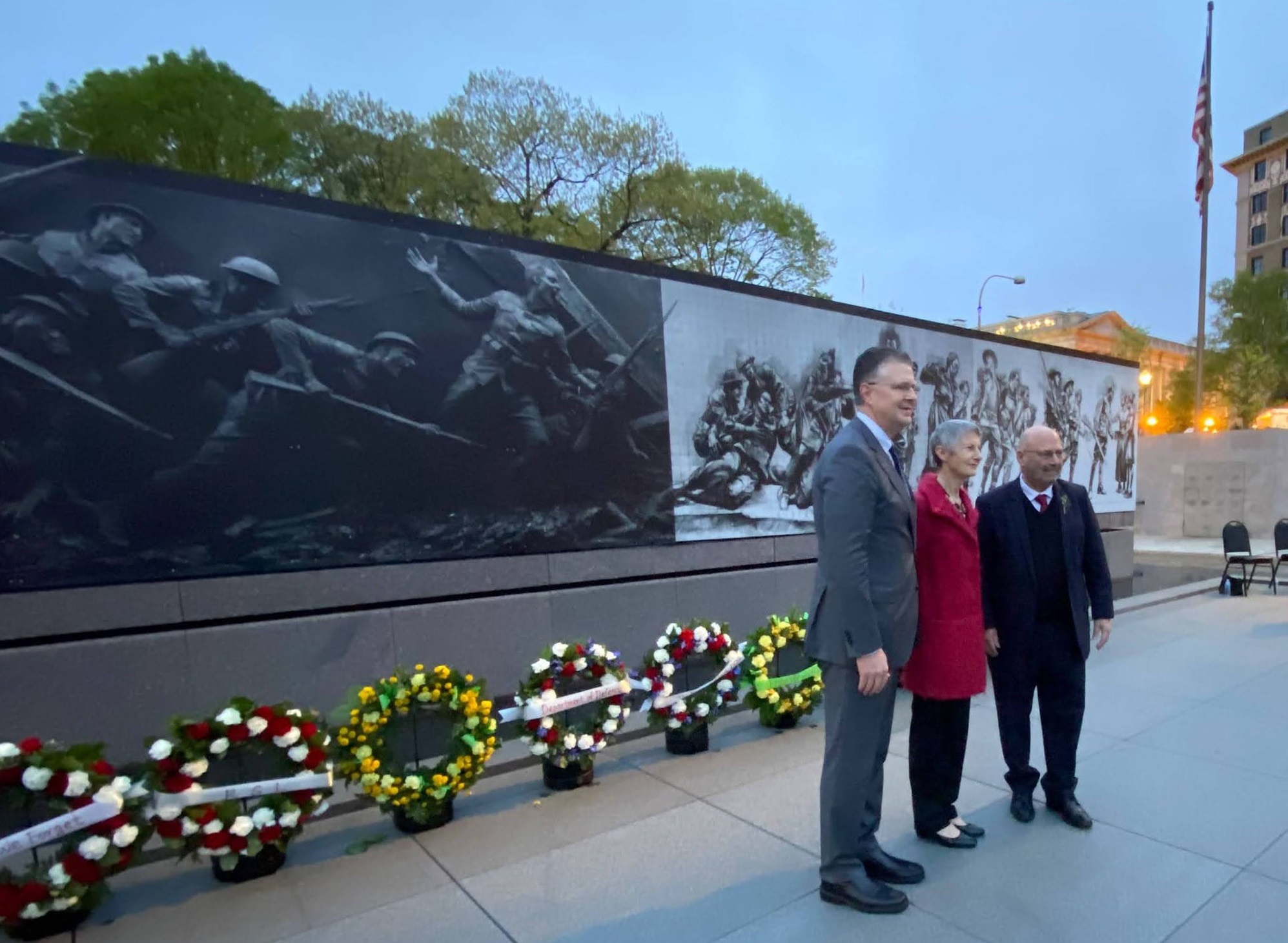 Three people stand in front of the WWI memorial