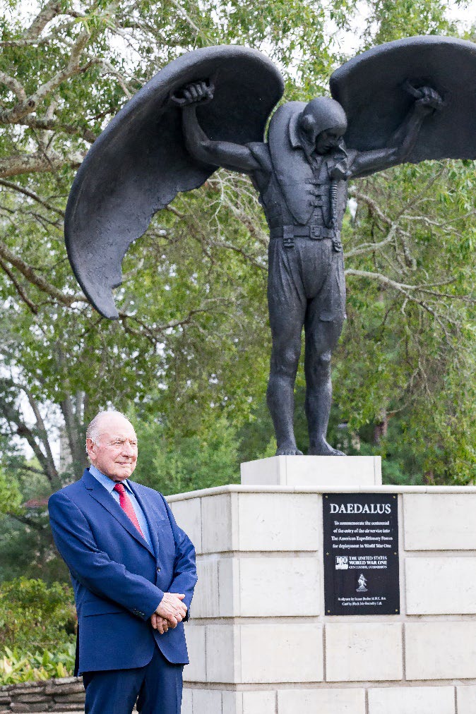 A man stands to the left of a statue of Daedalus