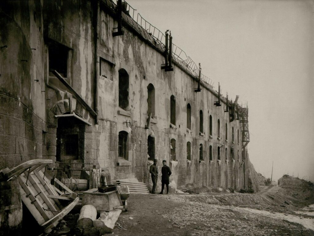 Two men standing outside a concrete building.