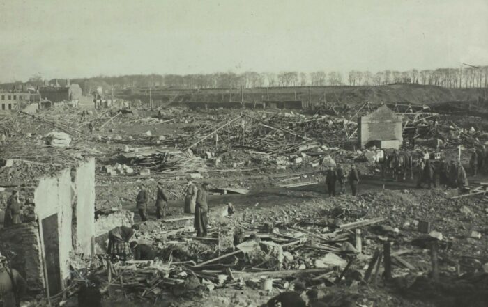 People standing around the remains of a bombed city.